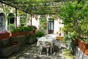 un patio con tavolo e sedie sotto un pergolato di Camera doppia con bagno e terrazza a Venezia