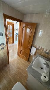 a bathroom with a sink and a toilet and a door at Ca la Cabrera in Alfara de Carles +31 photos