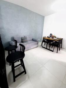 a living room with a couch and a table and chairs at Apto térreo com ar, próximo ao shopping Caruaru com área de lazer completa! in Caruaru