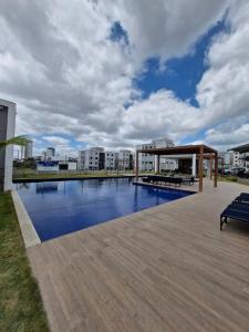 a building with a swimming pool in a city at Apto térreo com ar, próximo ao shopping Caruaru com área de lazer completa! in Caruaru