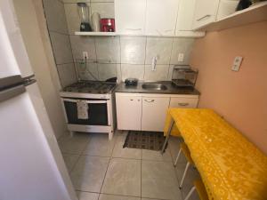 a small kitchen with a stove and a sink at Meu Cantinho na ilha in Fernando de Noronha