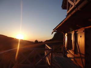 a barn with the sun setting in the background at Dom Kawa na Kotarzu in Brenna