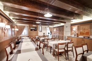 una sala da pranzo con tavoli bianchi e pareti in legno di Penzion Kiska Levoča a Levoča