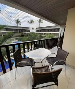 einen Balkon mit einem weißen Tisch und Stühlen in der Unterkunft Flat no Nannai Residence - Muro Alto in Porto De Galinhas + 18 Fotos