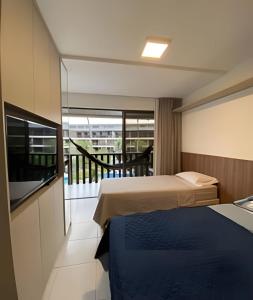 ein Hotelzimmer mit Bett und Balkon in der Unterkunft Flat no Nannai Residence - Muro Alto in Porto De Galinhas