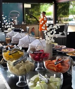 ein Tisch mit Tellern voller Essen auf einem Tisch in der Unterkunft Flat no Nannai Residence - Muro Alto in Porto De Galinhas