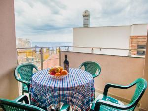 Bel&Rus Sea Apartment في بودفا: طاولة مع زجاجة من النبيذ وصحن من الفاكهة