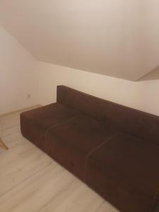 a brown couch sitting in a living room at Hotel Kaukaz in Kraków