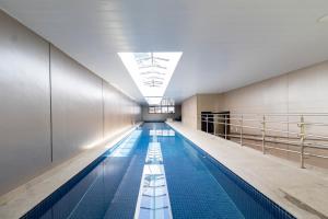 a swimming pool with a skylight in a building at HUB Alto da Boa Vista - Studios por temporada in Sao Paulo