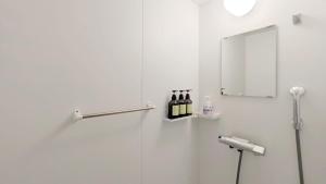 - une douche avec une porte en verre et des bouteilles de vin dans l'établissement Yonagunijima Hotel Munbu Stay Higawahama - Vacation STAY 14748v, à Sonai