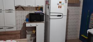a kitchen with a refrigerator with a tv on it at Cantinho do sonho in São Sebastião