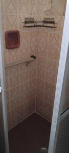 a small bathroom with a tiled shower with a shelf at Cantinho do sonho in São Sebastião