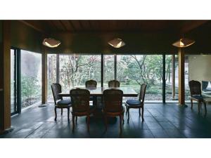 a dining room with a table and chairs and windows at Ryokan Akebono - Vacation STAY 97660v in Saga