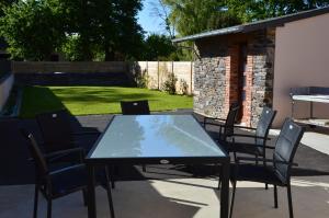 una mesa y sillas en un patio en Gîte Des Hirondelles en Pipriac