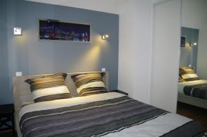 een slaapkamer met een bed met een foto aan de muur bij Gîte Des Hirondelles in Pipriac