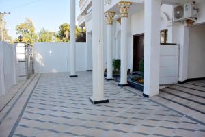 ラーワルピンディーにあるMehmaan Lodgeの中庭付白い柱の建物