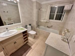 a bathroom with a sink and a toilet and a shower at Sunny terrace & Heated pool in Playa de las Americas +12 photos
