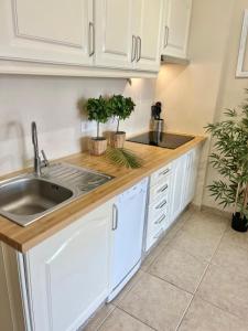 a kitchen with white cabinets and a sink at Sunny terrace & Heated pool in Playa de las Americas