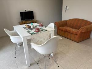 ein Wohnzimmer mit einem weißen Tisch und Stühlen in der Unterkunft Departamento Berlín in Formosa