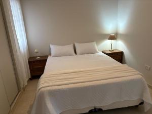 ein Schlafzimmer mit einem großen weißen Bett und zwei Nachttischen in der Unterkunft Departamento Berlín in Formosa