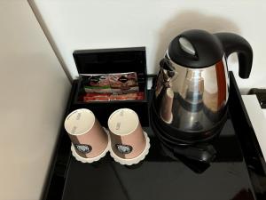 a counter with a coffee pot and cups on it at Hotel Gloria Budapest City Center in Budapest
