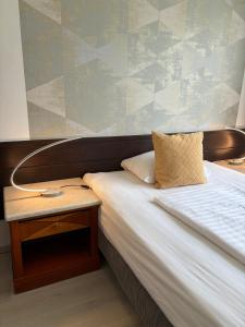a bedroom with a bed with a nightstand next to it at Hotel Gloria Budapest City Center in Budapest
