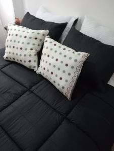 dos almohadas de lunares sentadas encima de una cama en Casa cerca de concierto Marc Anthony Med Plus, en Bogotá