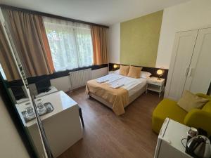 a small bedroom with a bed and a couch at Hotel Gloria Budapest City Center in Budapest