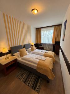 a bedroom with two beds and a table and a window at Hotel Gloria Budapest City Center in Budapest