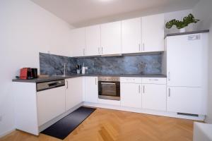 a kitchen with white cabinets and stainless steel appliances at Home Sweet Home - Leopold in Vienna