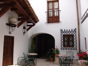 a courtyard with tables and chairs in a building at Apartamentos La Columna in Chinchón