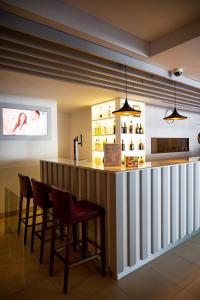 a bar in a restaurant with chairs and lights at Park Hotel Porto Valongo in Valongo