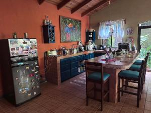 a kitchen with a refrigerator and a table with chairs at Yellow House in Huacalillo