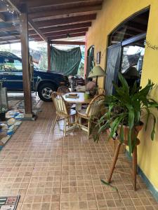 a patio with a table and chairs and a car at Yellow House in Huacalillo +8 photos