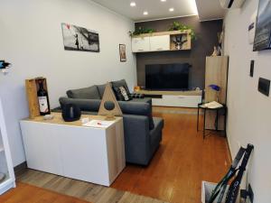 a living room with a couch and a tv at Al Cortile in Santa Maria di Licodia