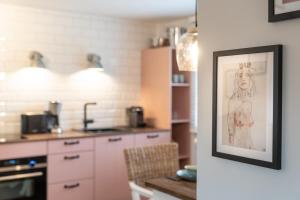 a kitchen with a painting of a woman on the wall at Ankerplatz SPO 2 in Böhl +10 photos