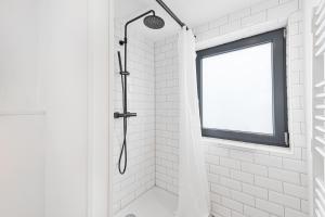a shower in a white bathroom with a window at Ankerplatz SPO 2 in Böhl
