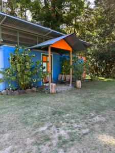 a blue house with a porch and some trees at Hospedaje Casa Monge in San Gerardo de Dota