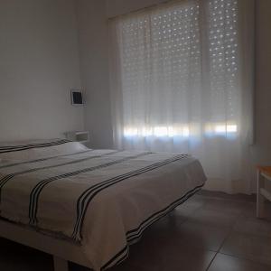 a bedroom with a bed and a large window at Cabaña del monte 1 in Monte Hermoso