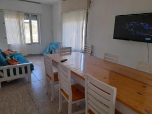 a dining room with a large wooden table and chairs at Cabaña del monte 1 in Monte Hermoso