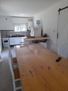 a kitchen with a wooden table and a counter top at Cabaña del monte 1 in Monte Hermoso