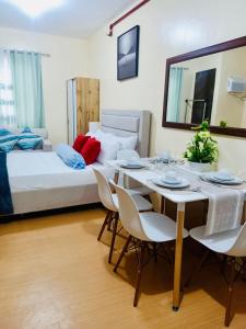 une chambre avec un lit, une table et des chaises dans l'établissement Coho The Hermosa - Staycation Studio Unit and Balcony View with Swimming Pool and Open Court access, à Manille