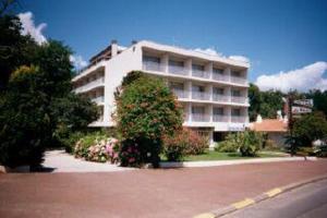 a large white building with a bush in front of it at Hotel du Parc in Arcachon
