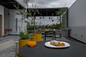 a table with a plate of food and a glass of orange juice at Casa Calderon by Capitalia in Mexico City