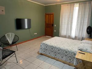 a bedroom with a bed and a television on the wall at Big Sloth Apartment in Fortuna