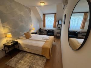 a small bedroom with a bed and a mirror at Hotel Gloria Budapest City Center in Budapest