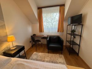 a bedroom with a desk and a bed and a window at Hotel Gloria Budapest City Center in Budapest