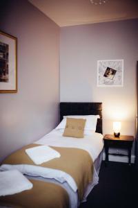 - une chambre avec un lit et une table avec une lampe dans l'établissement Coalminer's Cottage, à Gateshead
