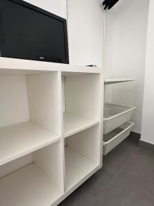 a white cabinet with a tv on top of it at Ático Rocamar in La Restinga