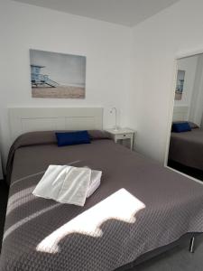 a bedroom with a large bed with a blanket at Ático Rocamar in La Restinga